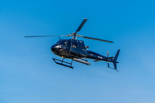Helicopter flying in clear sky, representing rotary-wing transport environments that require vibration-resistant aerospace cases and secure cargo handling systems