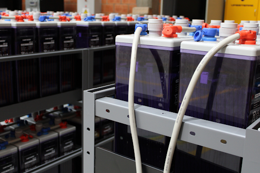 Large-format lithium-ion battery modules connected on metal rack, demonstrating engineered battery storage cabinet systems, electrical integration, and safe energy storage infrastructure in industrial environments.