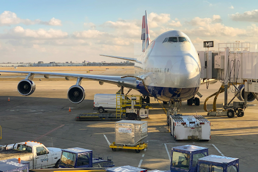 A white commercial airliner parked on an airport tarmac, representing air freight and the strict IATA DGR requirements that govern lithium battery shipments by air
