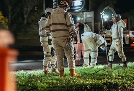 Workers in reflective, high-visibility safety gear, representing the corrective action and safety commitment companies demonstrate after a compliance issue is identified.