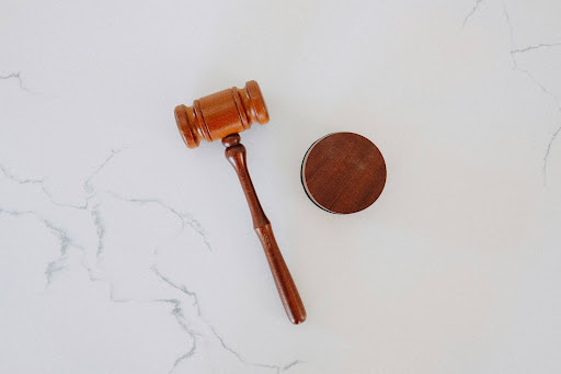 A wooden gavel on a marble surface, representing the administrative hearing and appeal stage of the hazmat enforcement process.